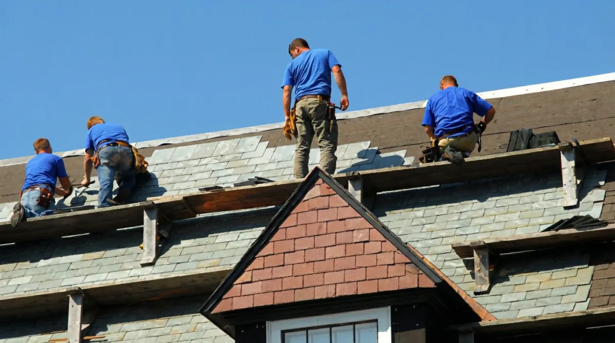 Roof replacement in progress with a team of professional contractors installing new shingles on a residential home in South Bend, IN